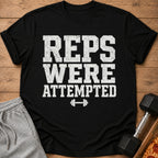 Black t-shirt with "REPS WERE ATTEMPTED" text and dumbbell graphic.
