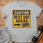 Grey t-shirt with yellow and black sign: CAUTION REST DAY AHEAD with arrow and roller.
