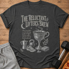 Dark gray t-shirt with "The Reluctant Lifter's Brew" graphic, coffee cup, kettle, dumbbell, sneaker, and towel.
