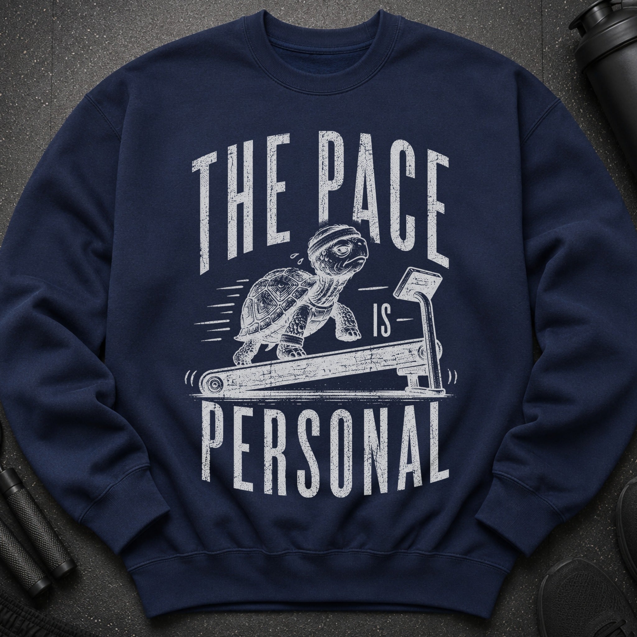 Navy sweatshirt with a turtle on a treadmill graphic and text "THE PACE IS PERSONAL."