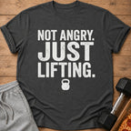 Dark grey t-shirt with white text "Not Angry. Just Lifting." and a kettlebell icon.