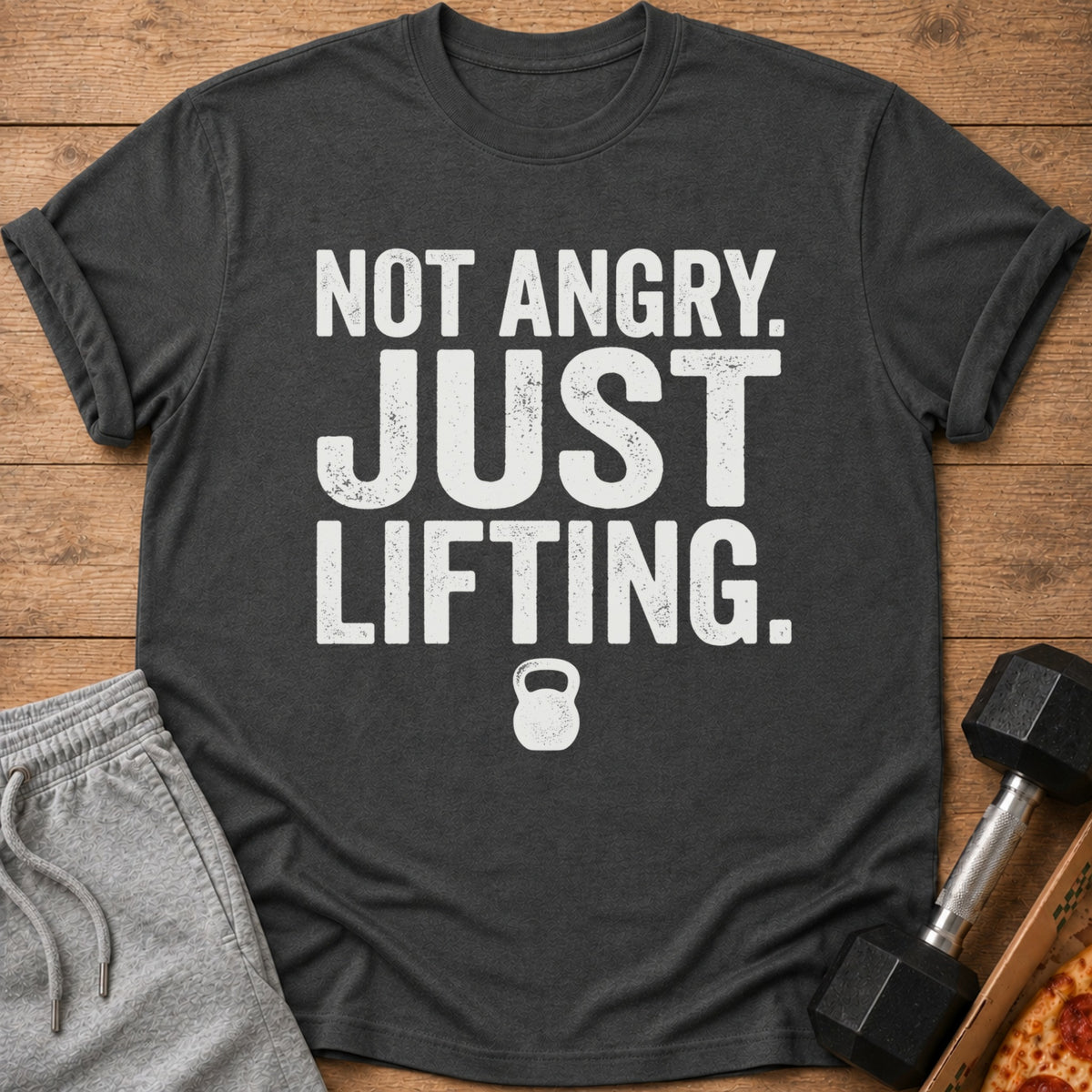 Dark grey t-shirt with white text "Not Angry. Just Lifting." and a kettlebell icon.