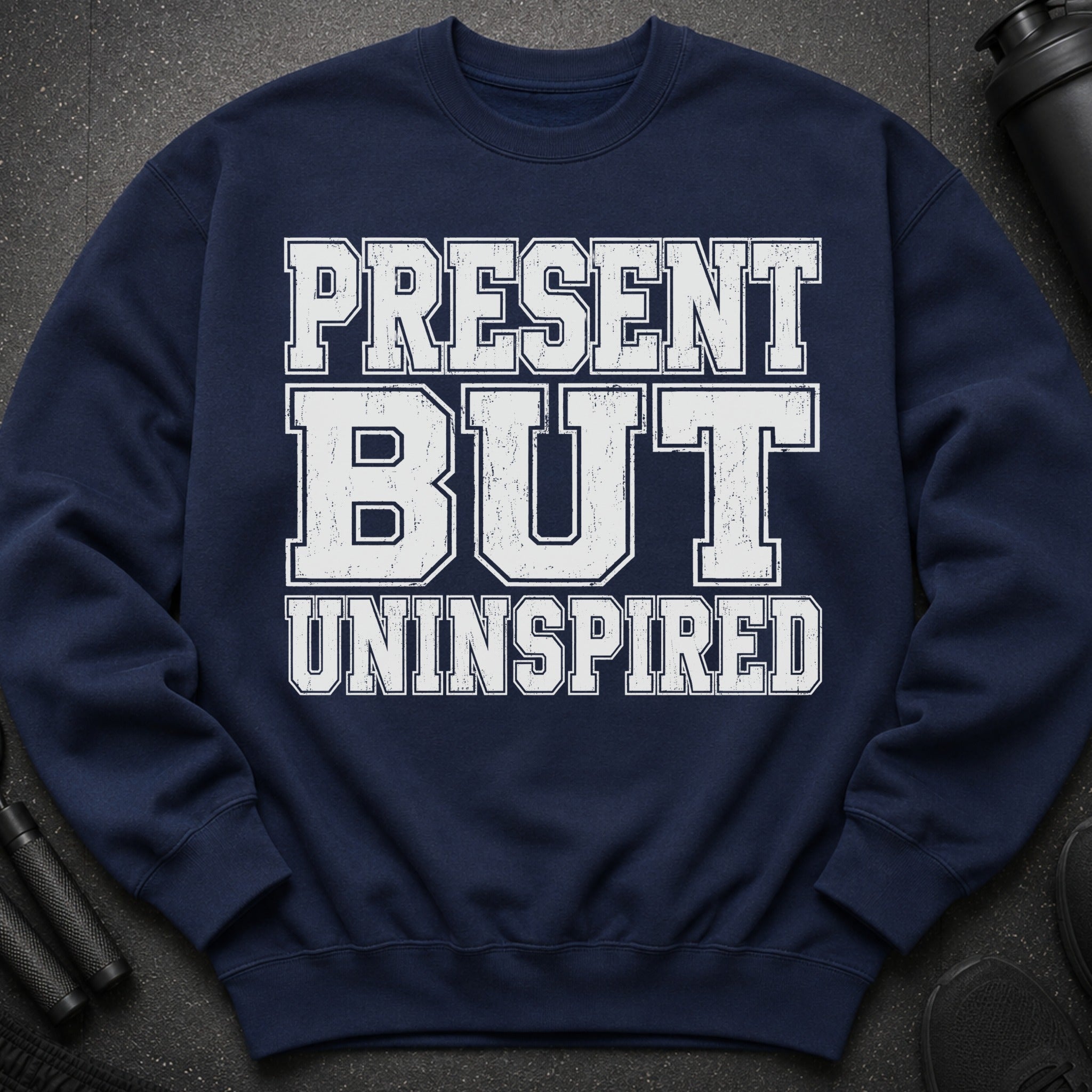 Navy sweatshirt with distressed white text reading "PRESENT BUT UNINSPIRED".