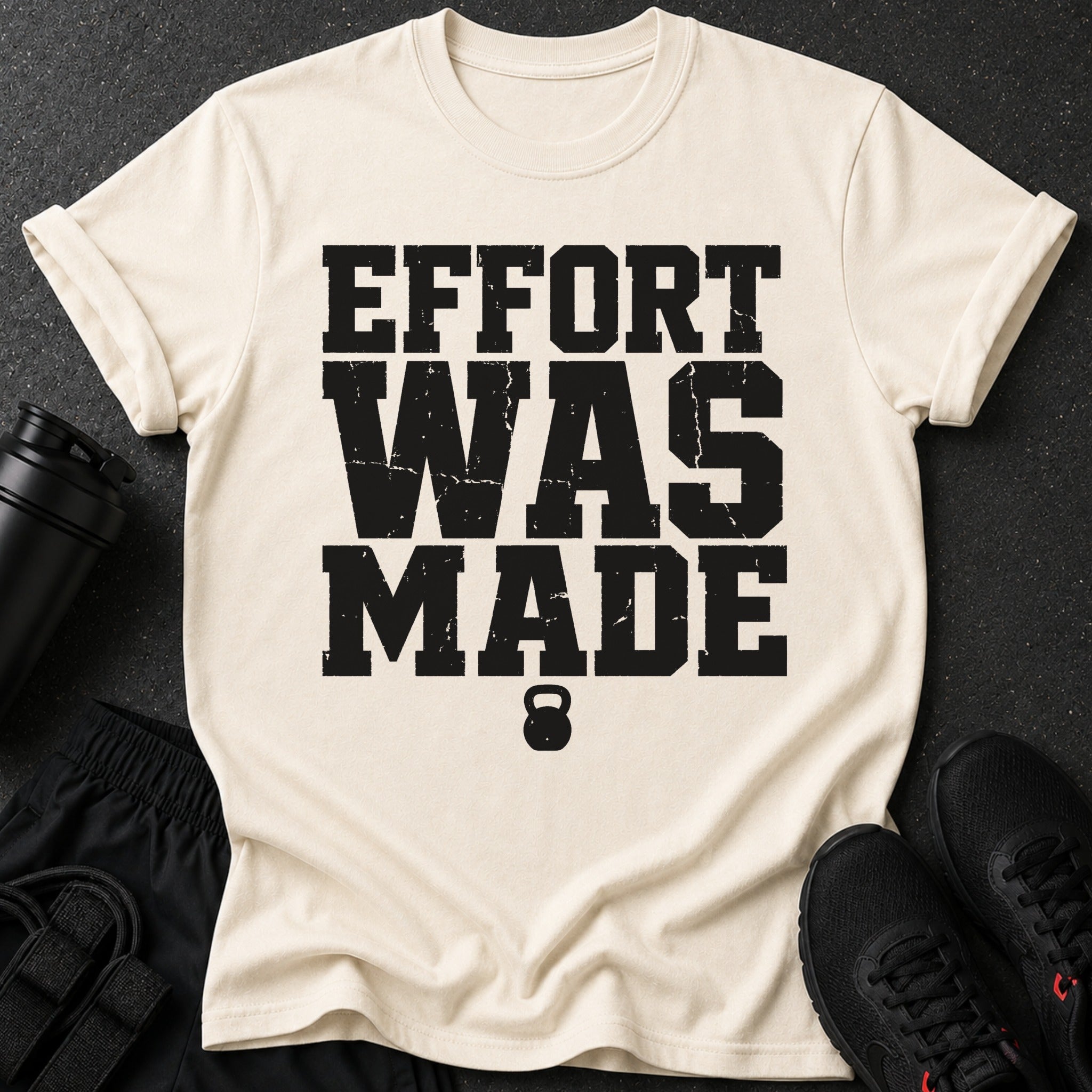Cream t-shirt with black distressed text "EFFORT WAS MADE" and a kettlebell.