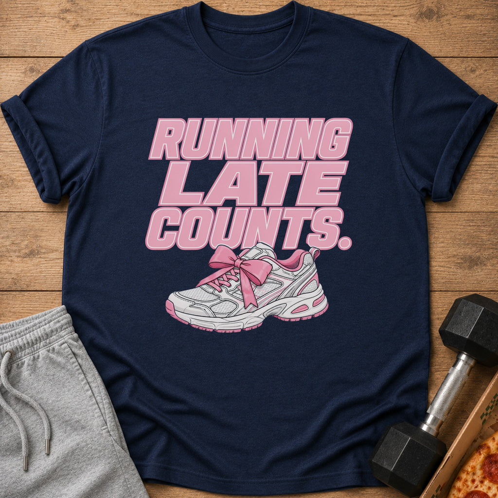 Navy t-shirt with pink text "RUNNING LATE COUNTS." and a pink bow-tied sneaker.