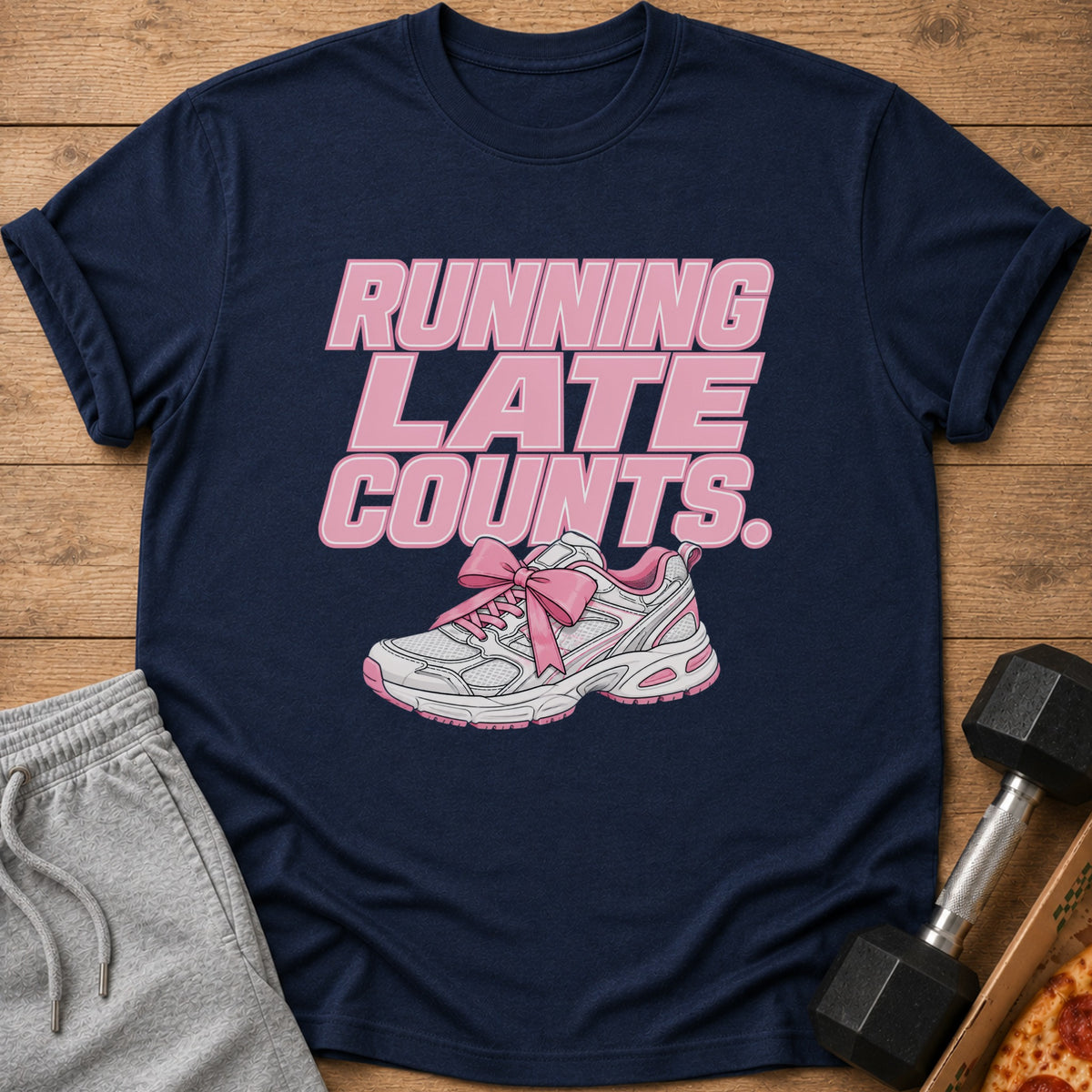 Navy t-shirt with pink text "RUNNING LATE COUNTS." and a pink bow-tied sneaker.
