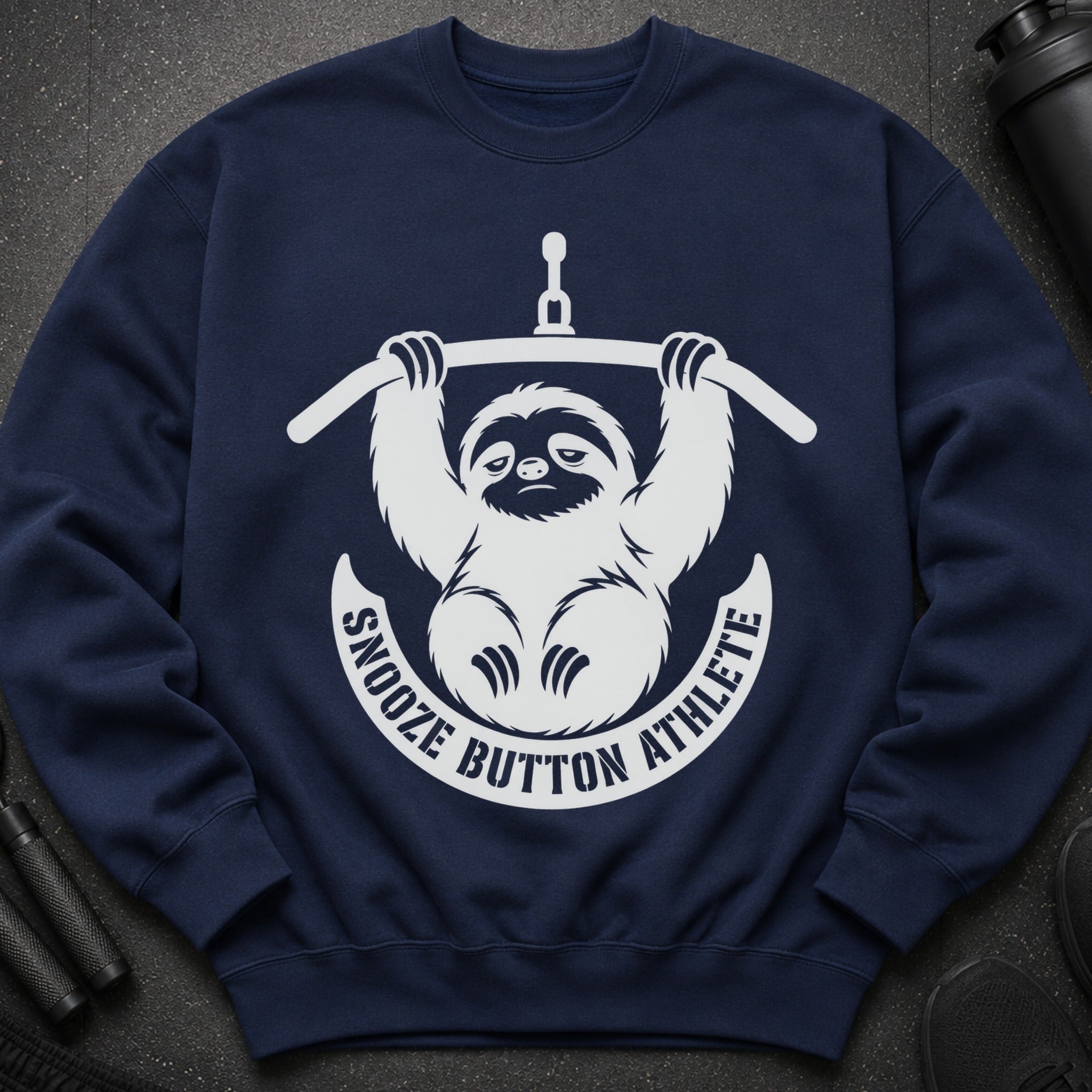 Navy sweatshirt with a white graphic of a sloth holding a barbell and text "Snooze Button Athlete."