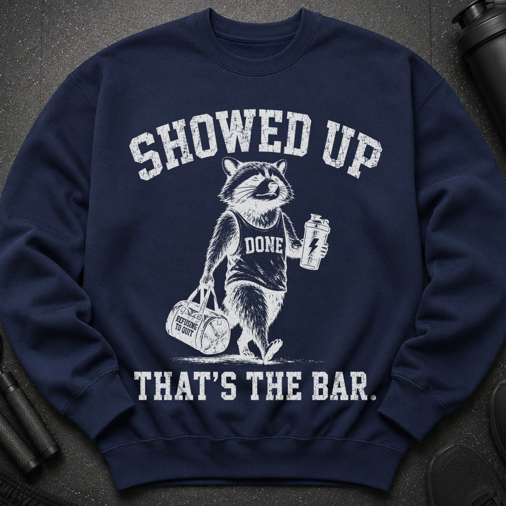 Navy sweatshirt with raccoon graphic and text: SHOWED UP, DONE, REFUSING TO QUIT, THAT'S THE BAR.
