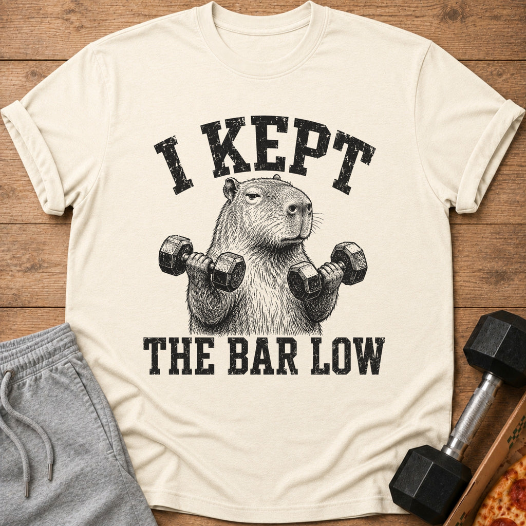 Cream t-shirt with capybara lifting weights graphic and text "I KEPT THE BAR LOW".