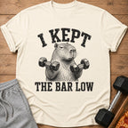 Cream t-shirt with capybara lifting weights graphic and text "I KEPT THE BAR LOW".