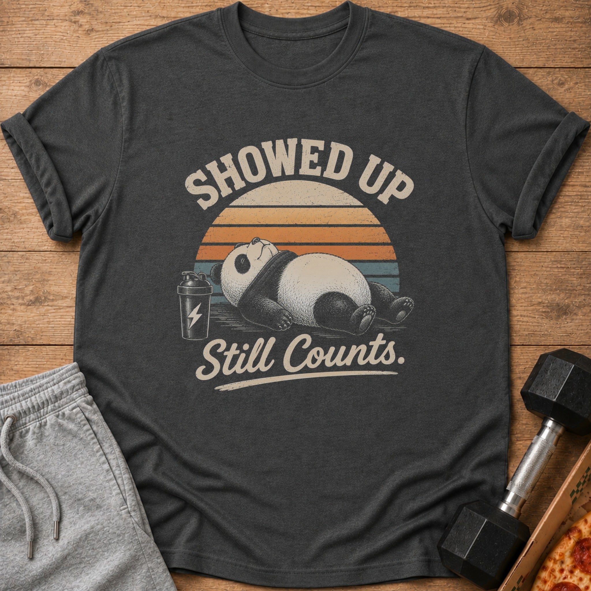 Dark t-shirt with a panda, shaker bottle, and text: Showed Up Still Counts.