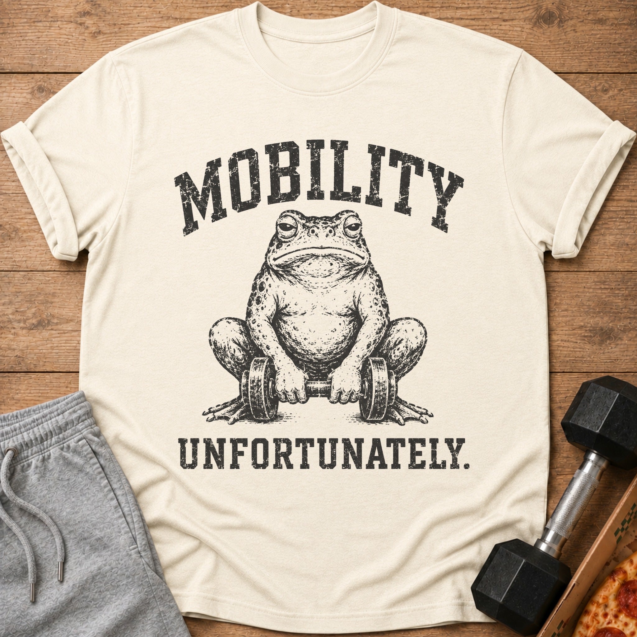 T-shirt with a distressed graphic of a frog holding dumbbells and the text MOBILITY UNFORTUNATELY.