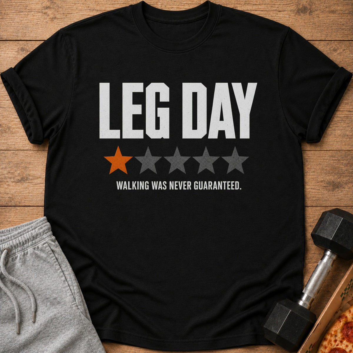 Black t-shirt with "LEG DAY" text, one orange and four gray stars, and "WALKING WAS NEVER GUARANTEED."
