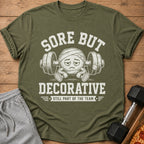 T-shirt with "Sore But Decorative Still Part of the Team" text and cartoon.