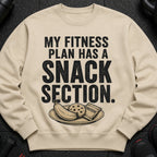 Light beige sweatshirt with "My Fitness Plan Has a Snack Section" text and snacks.