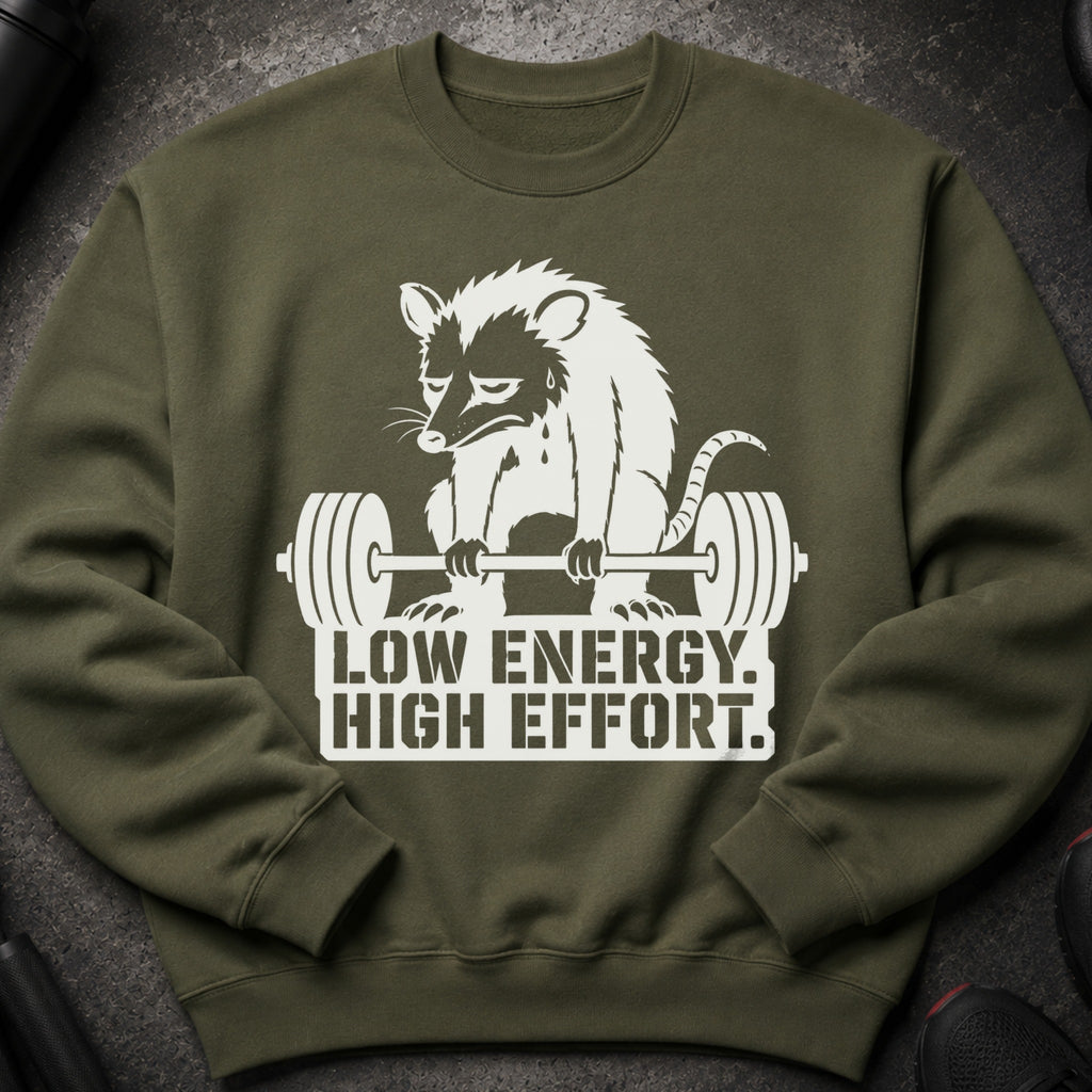 Olive green sweatshirt with a white graphic of a struggling opossum lifting weights and text.