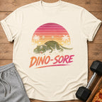 T-shirt graphic of a tired dinosaur with "Dino-Sore" text and a sunset.