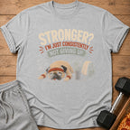 Grey t-shirt with a tired pug wearing a headband and wristbands, and text "Stronger? I'm just consistently not giving up."