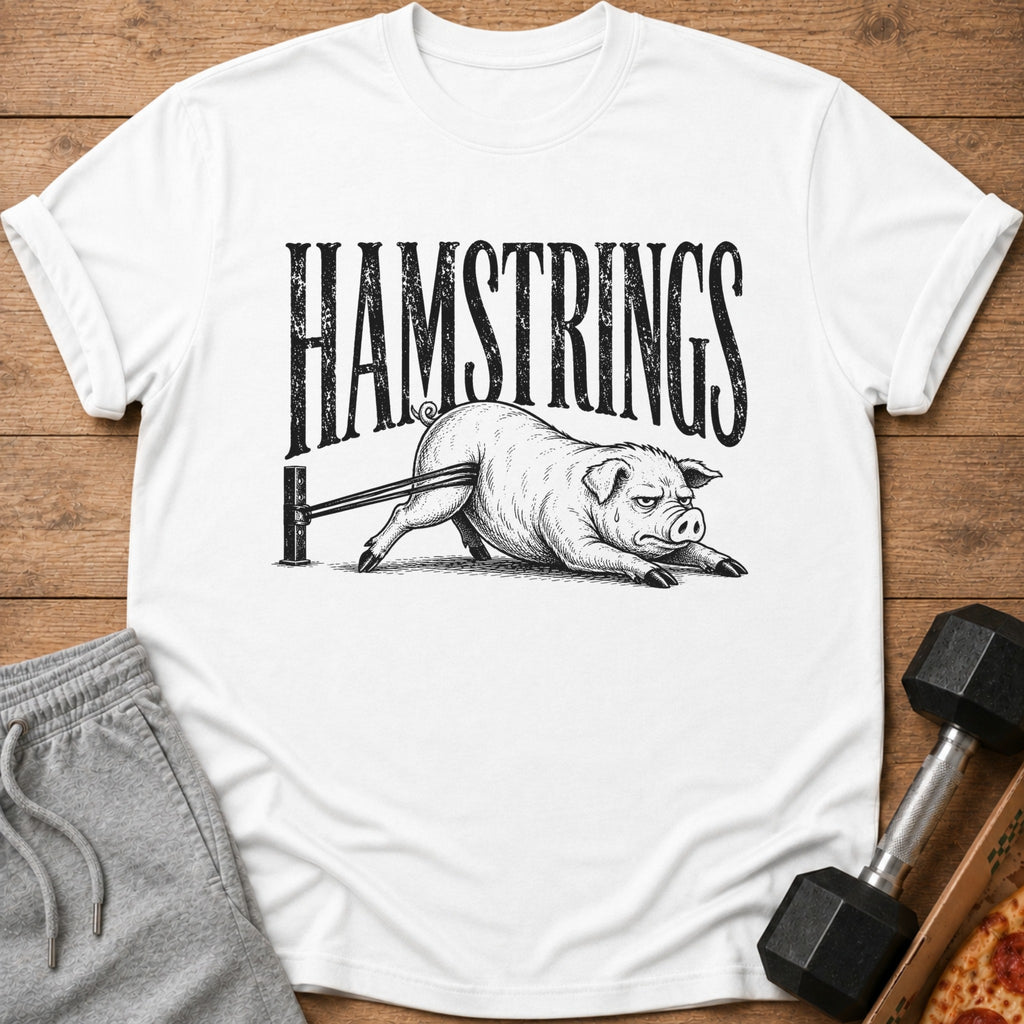 White t-shirt with black distressed text "HAMSTRINGS" above a pig doing resistance band exercises.