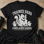 Black t-shirt with distressed graphic of a skunk lifting weights and text "TRAINED HARD COMPLAINED HARDER".