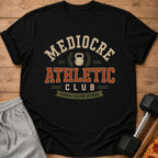 Black t-shirt with "Mediocre Athletic Club" text and "Proudly Below Average" banner.