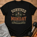 Black t-shirt with "Survived Monday" text, a sloth lifting weights, and 2024.