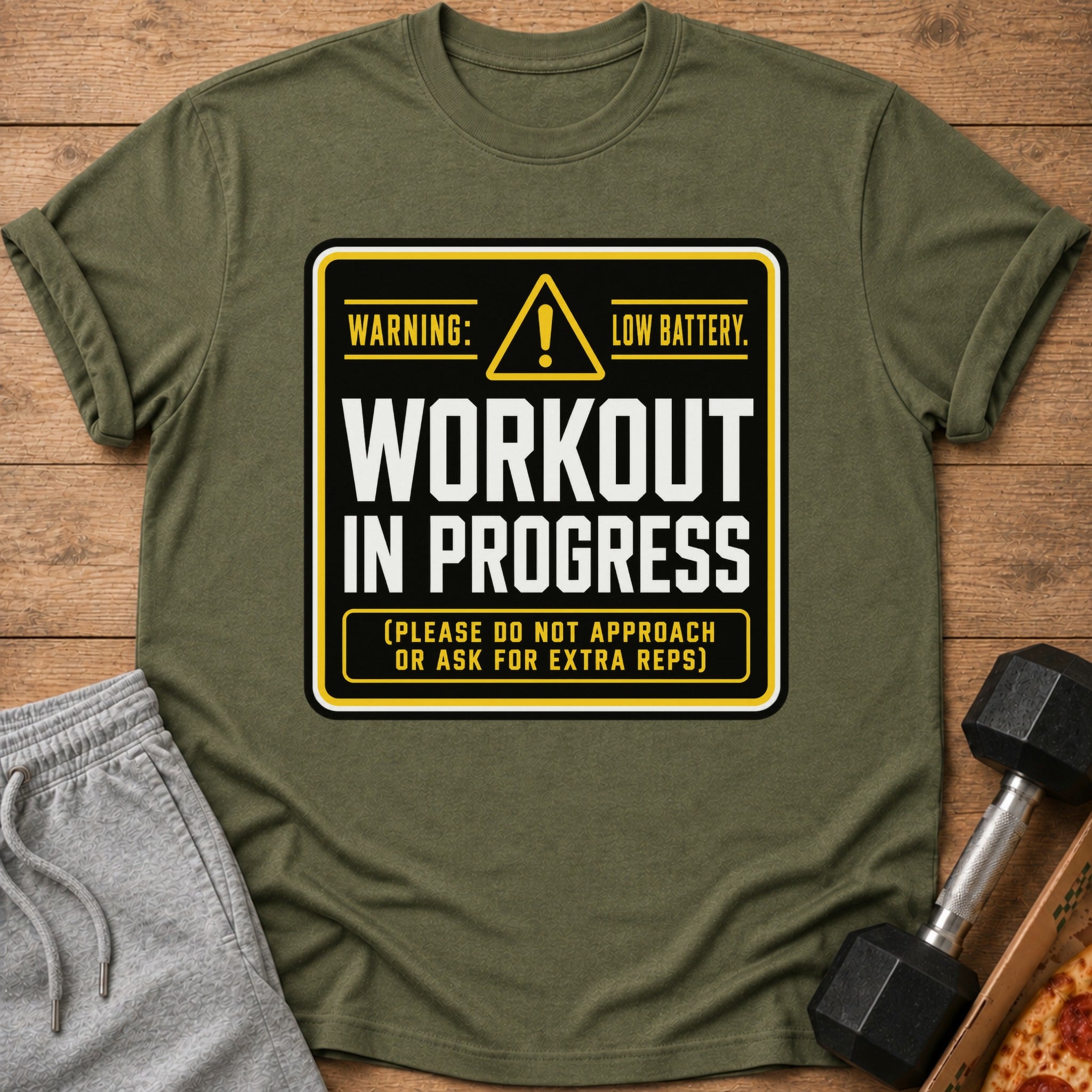 Olive green t-shirt with "Warning: Low Battery. Workout in Progress. (Please do not approach or ask for extra reps)" text.