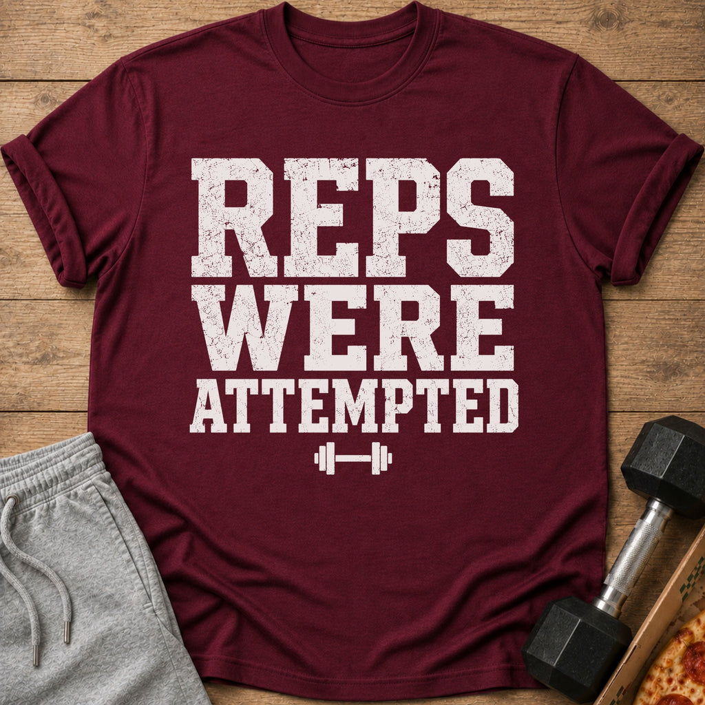 Maroon t-shirt with white distressed text "REPS WERE ATTEMPTED" and dumbbell graphic.