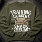 Olive green sweatshirt with "TRAINING ADJACENT. SNACK COMPLIANT" text and graphics.