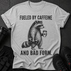 Grey t-shirt with raccoon graphic and text "Fueled by caffeine and bad form."