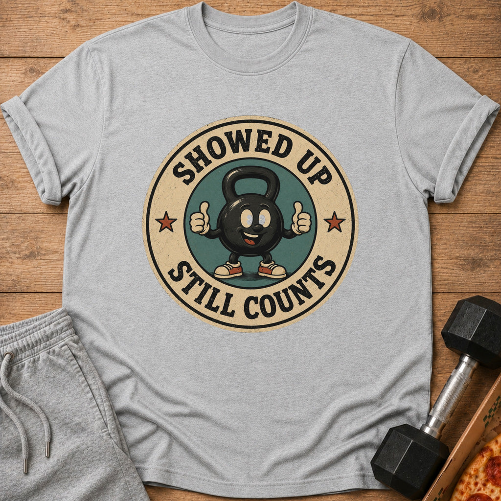 Grey t-shirt with cartoon kettlebell saying "Showed Up Still Counts"