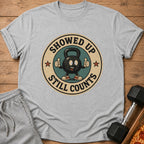 Grey t-shirt with cartoon kettlebell saying "Showed Up Still Counts"