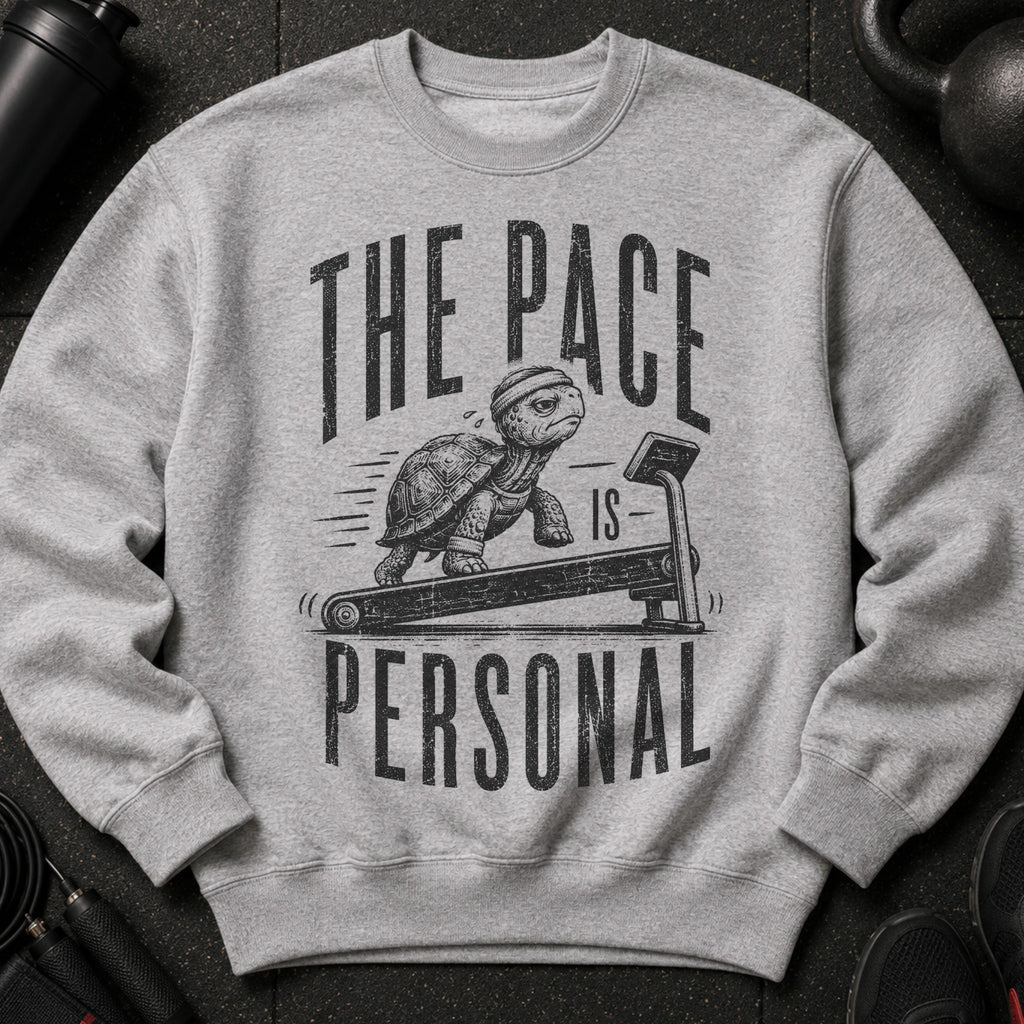 Grey sweatshirt with distressed graphic of a turtle on a treadmill, text reads "THE PACE IS PERSONAL".