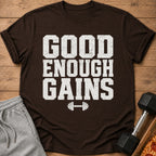 Brown t-shirt with white text "GOOD ENOUGH GAINS" and dumbbell graphic.
