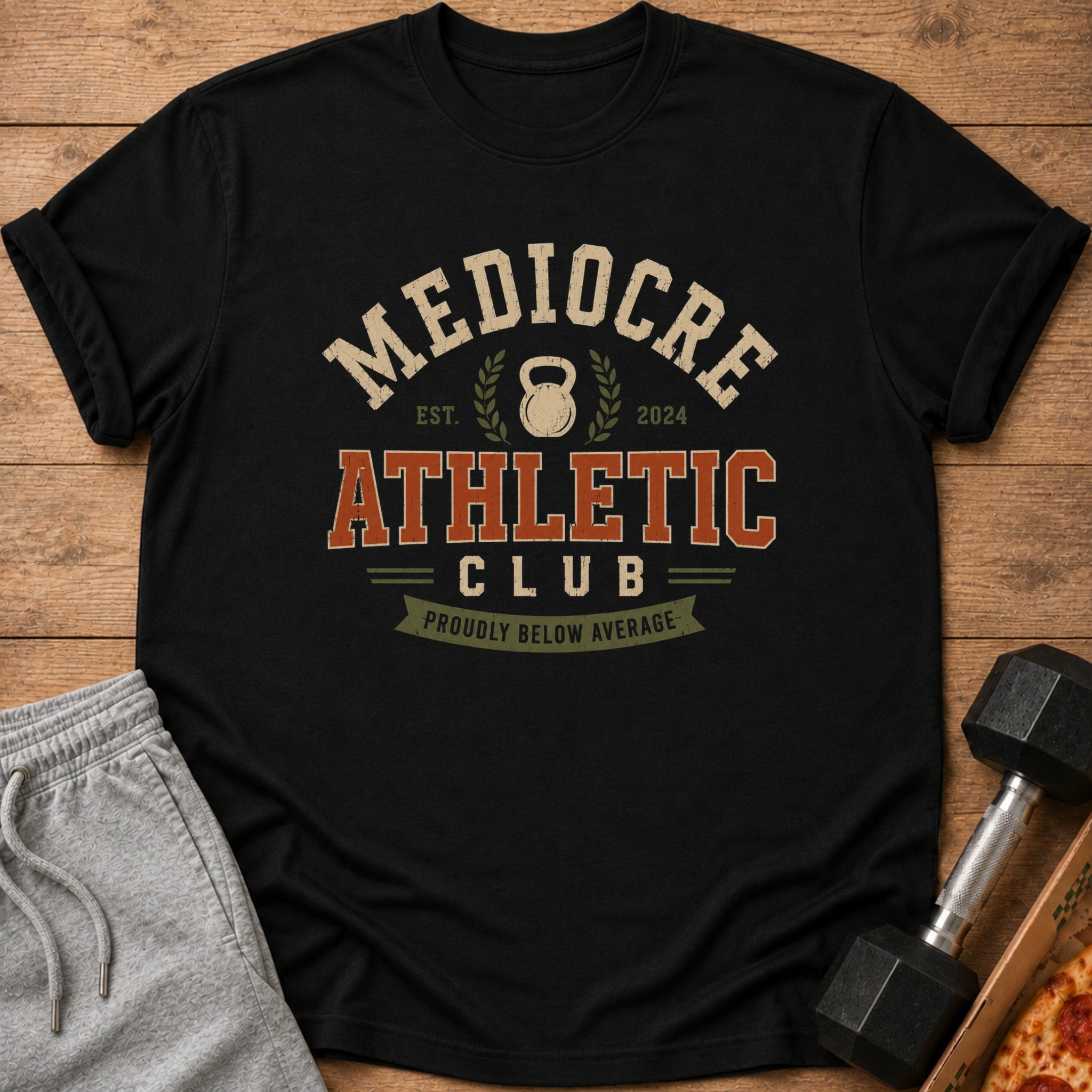 Black t-shirt with "Mediocre Athletic Club" and "Proudly Below Average" text.