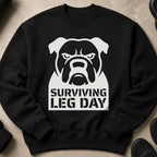 Black sweatshirt with a white bulldog graphic and "Surviving Leg Day" text.