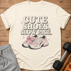Cream t-shirt with "CUTE SHOES. SLOW PACE." text and pink sneakers illustration.