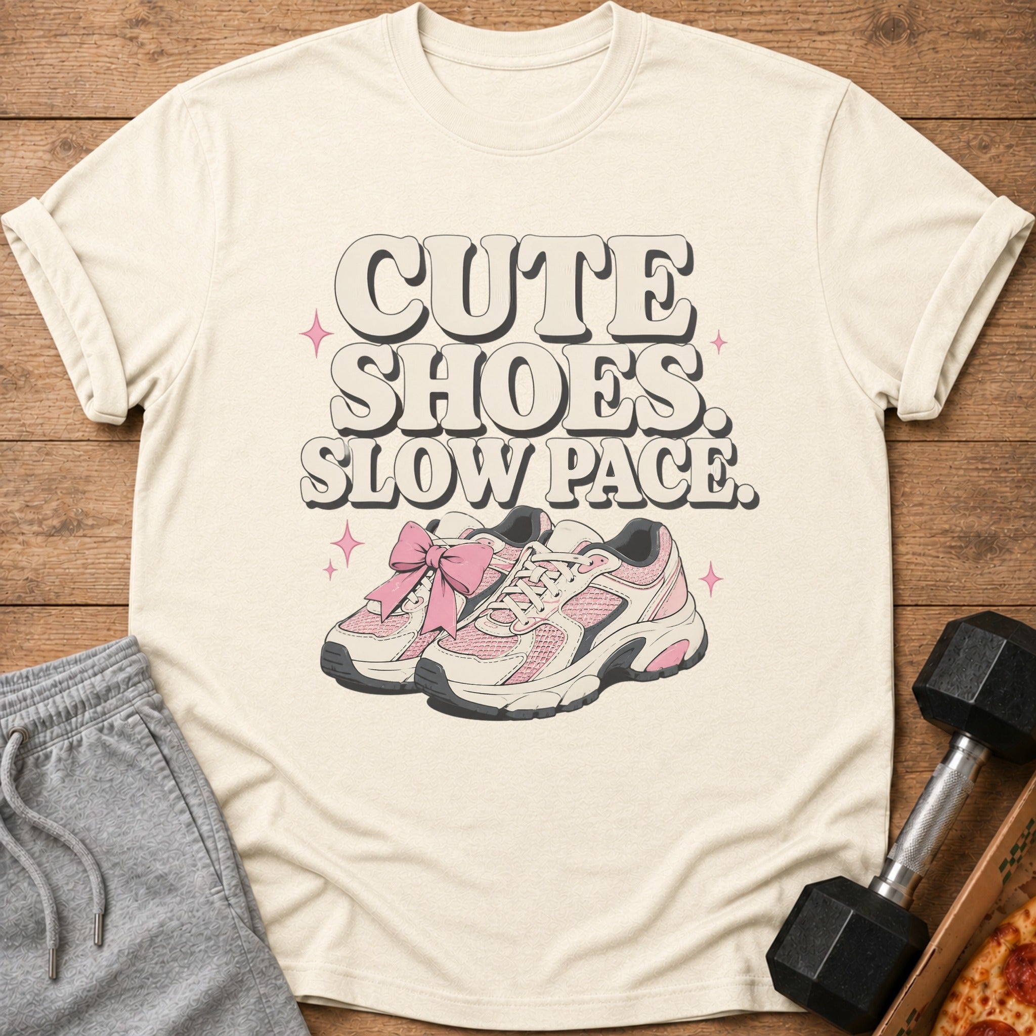 Cream t-shirt with "CUTE SHOES. SLOW PACE." text and pink sneakers illustration.
