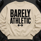 Cream sweatshirt with black text "BARELY ATHLETIC" and dumbbell graphic.