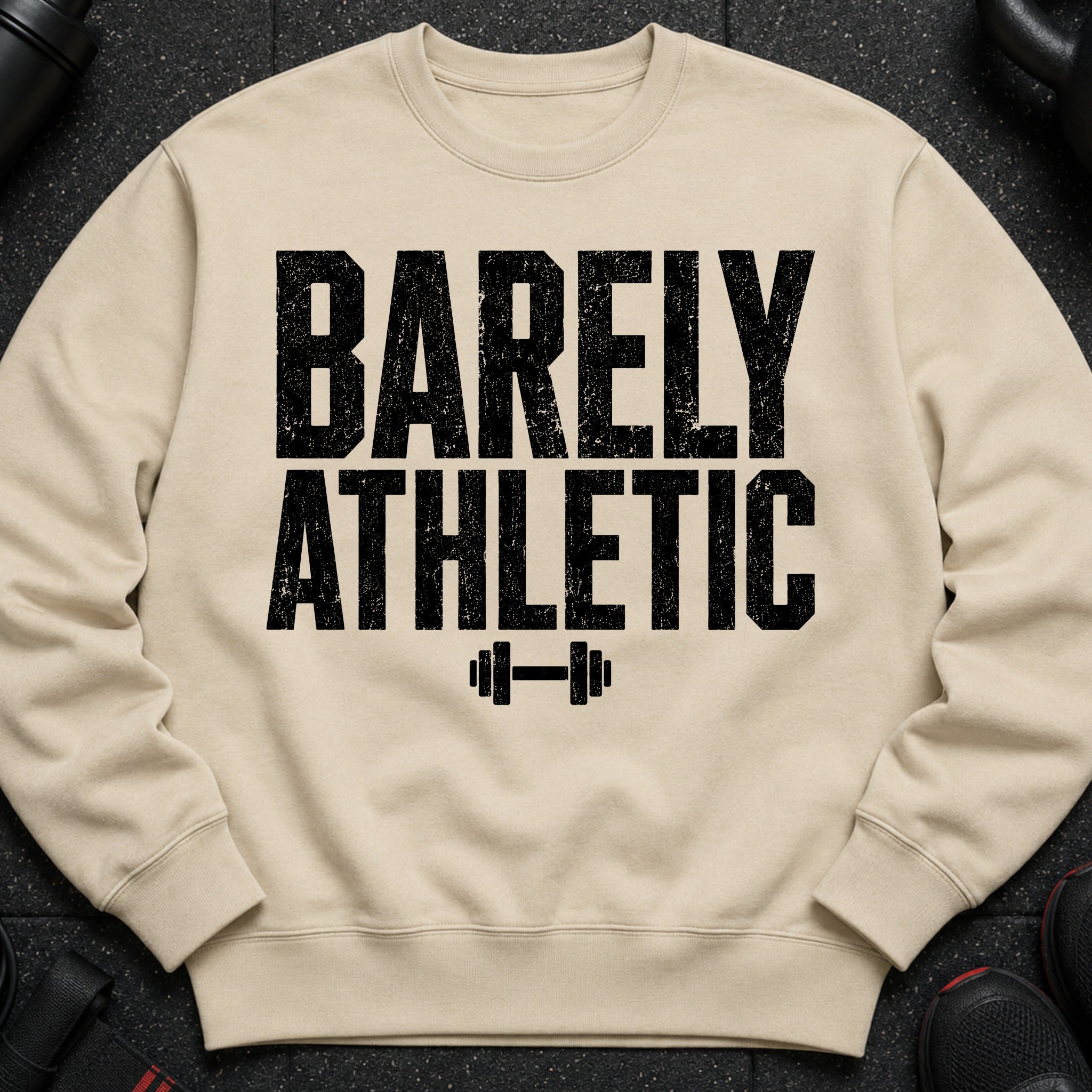 Cream sweatshirt with black text "BARELY ATHLETIC" and dumbbell graphic.