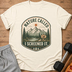 Cream t-shirt with "Nature Called I Screened It." mountain graphic.
