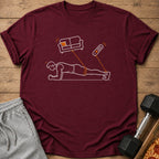 Maroon t-shirt with a white outline drawing of a man planking, tethered to a couch and remote.