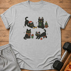 Grey t-shirt with a graphic of four black cats in festive poses and Christmas elements.