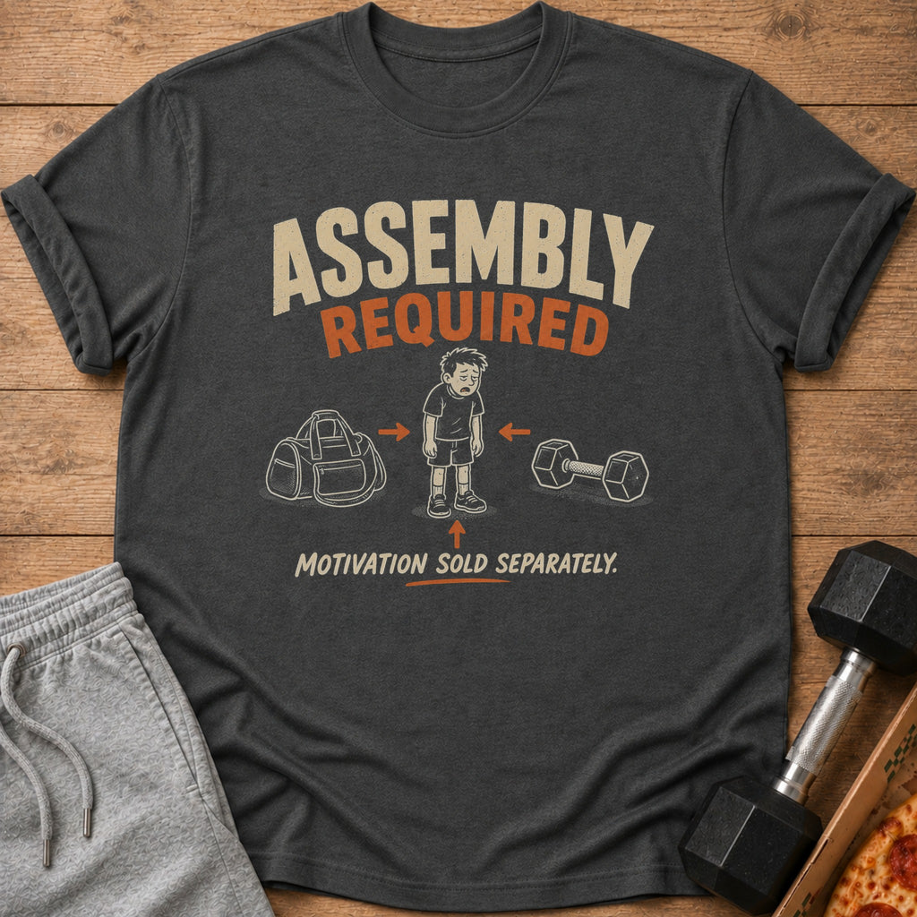 Dark gray t-shirt with "Assembly Required" and a tired boy between a gym bag and dumbbell.