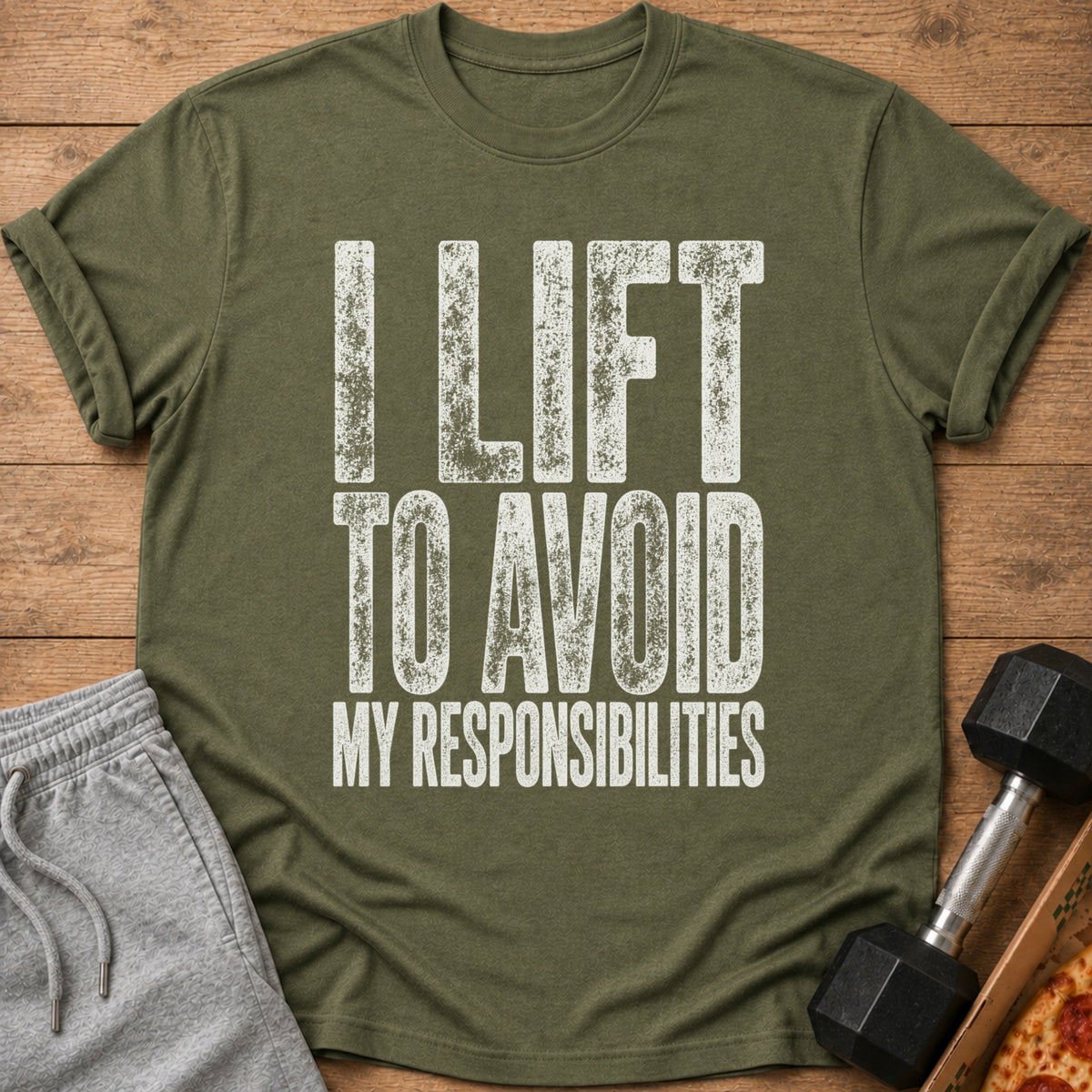 Olive green t-shirt with white text that reads "I LIFT TO AVOID MY RESPONSIBILITIES".