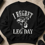 Black sweatshirt with distressed white text "I REGRET LEG DAY" and a flamingo holding a kettlebell.