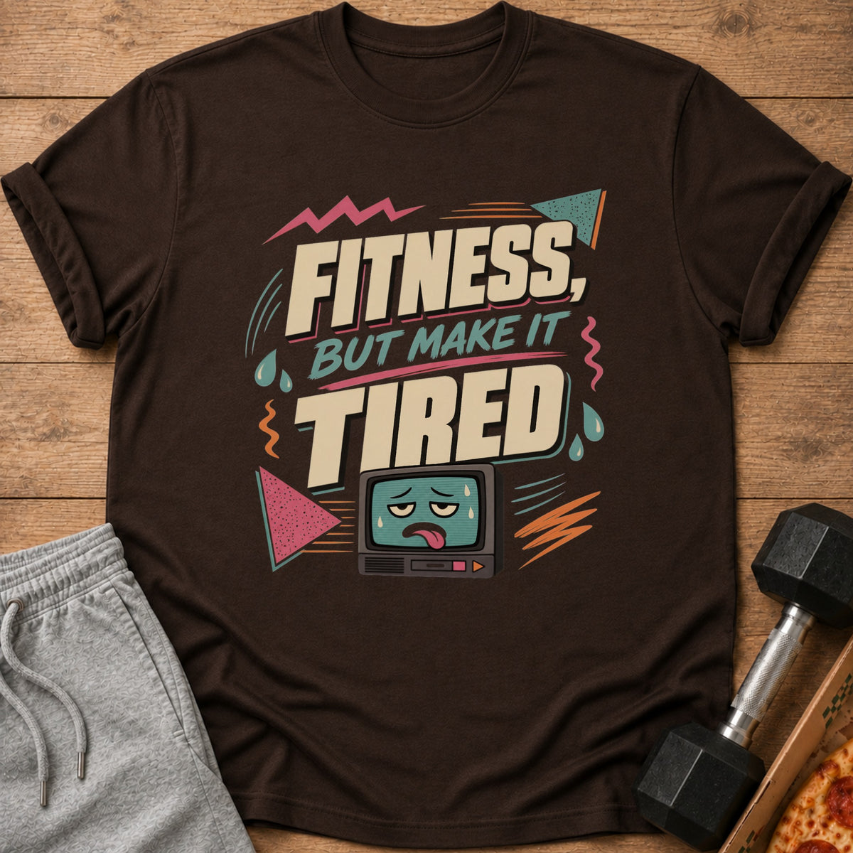 Brown t-shirt with text "Fitness, but make it tired" and cartoon TV.