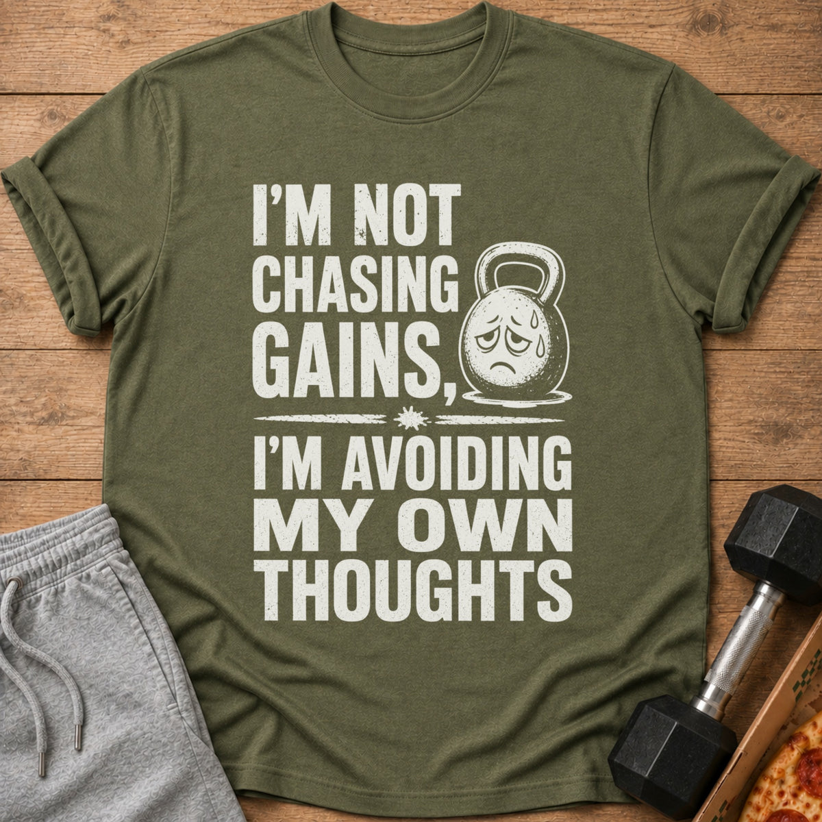 Green t-shirt with "I'm not chasing gains, I'm avoiding my own thoughts" text and kettlebell.
