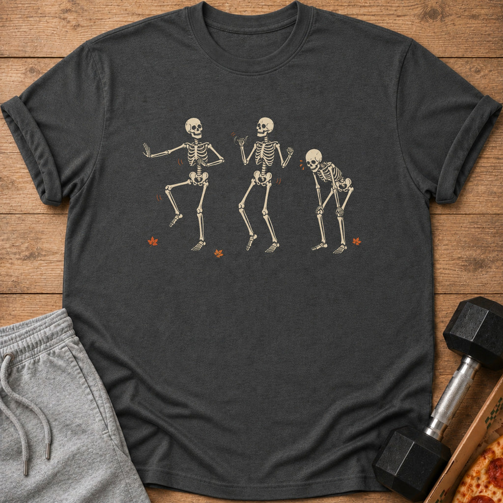 Three dancing skeletons graphic on a dark gray t-shirt with autumn leaves.