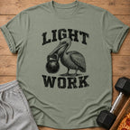 Olive green t-shirt with black distressed text "LIGHT WORK" and a pelican holding a kettlebell.